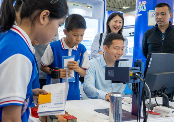 参加活动小学生在山东电子职业技术学院激光雕刻机展位前排起了“长龙”